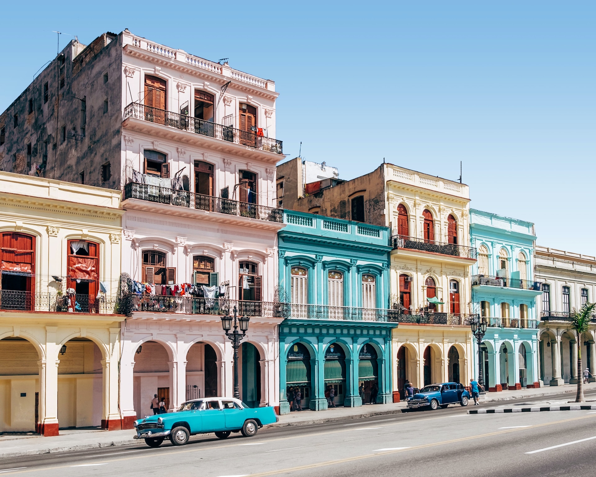 A Street Scene In Havana'S Cityscape, Encapsulating The Unique Beauty Of A Cuban Vacation.