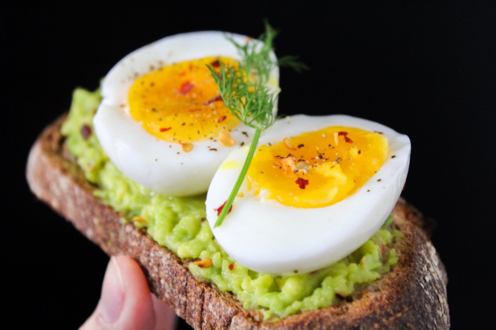 Sliced Egg On Top Of Green Salad With Bread