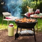 A Barbecue Grill With Food And Drinks On It