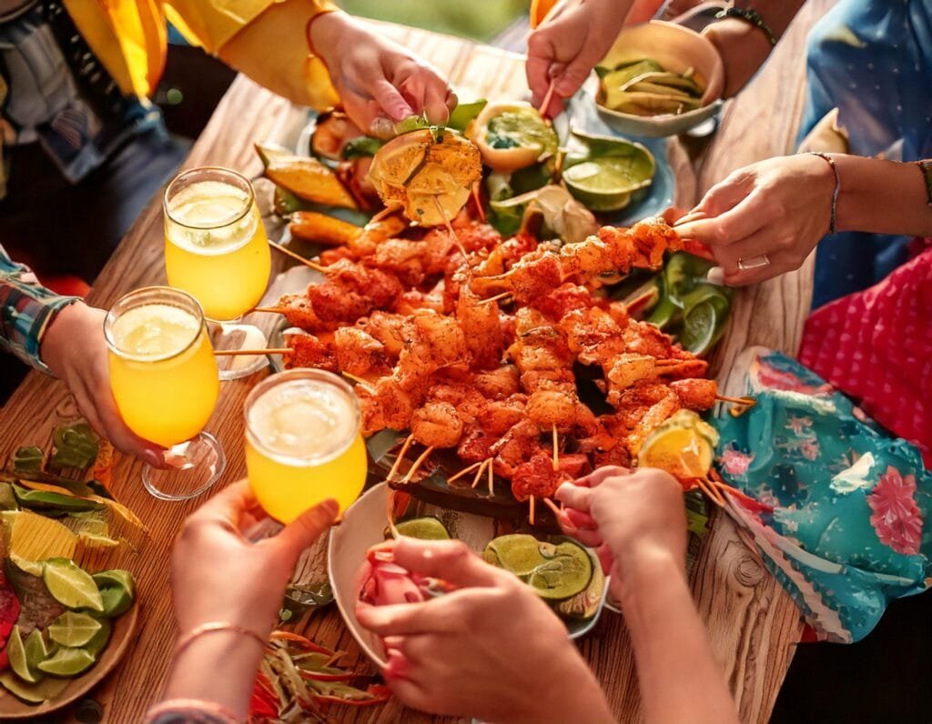 A Group Of People Holding Food On A Table